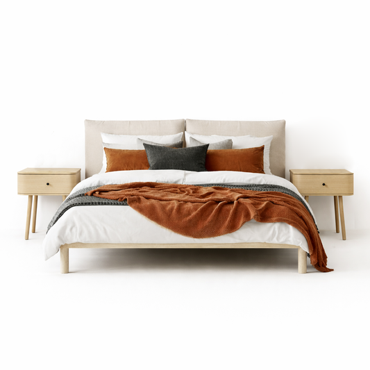 Bed with brown blanket and pillows in a minimalistic bedroom setting