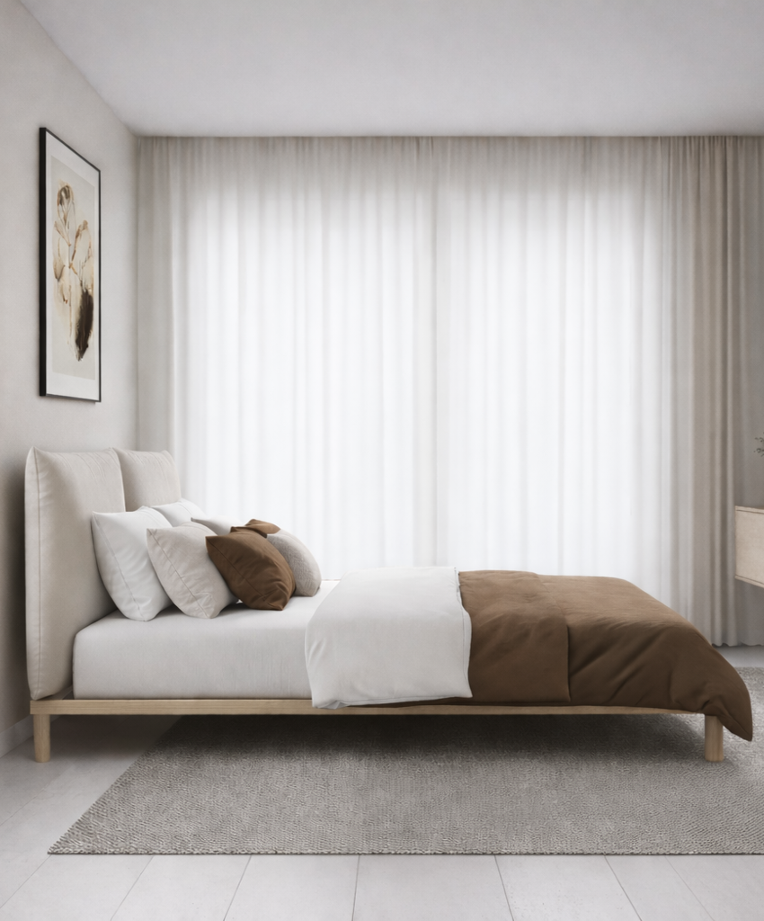 Modern bedroom with a bed featuring a brown and white comforter, pillows, and a large window with curtains.