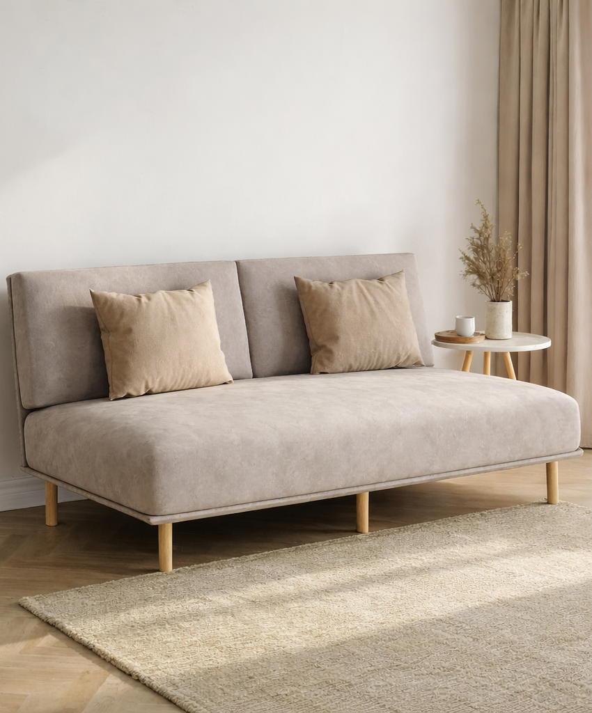 Beige two seater sofa positioned in a bright living room corner with a coffee table and soft neutral minimalist decor.