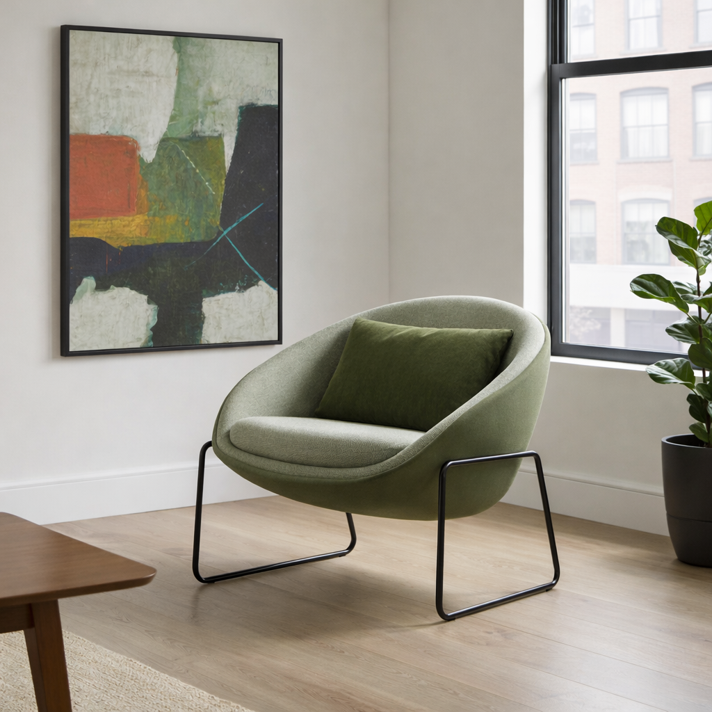 Modern green armchair in a room with abstract art and a window.