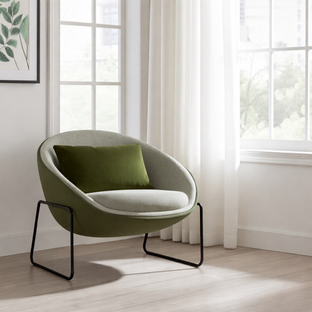 Modern green armchair with a cushion in a bright room with large windows.