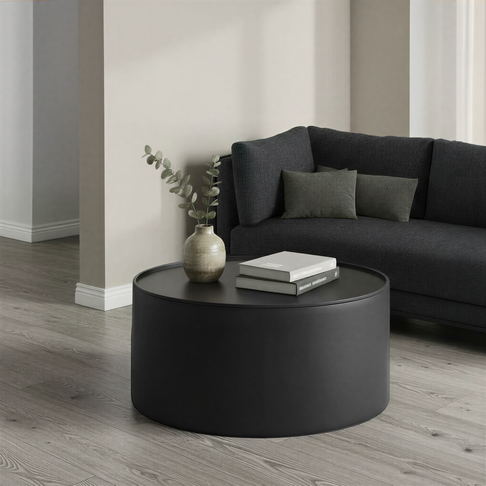 Modern living room with a black round coffee table and black sofa.