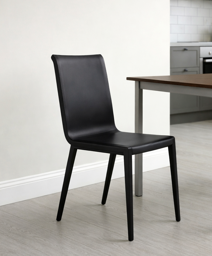 Black chair in a kitchen/diner with a wooden table and white walls