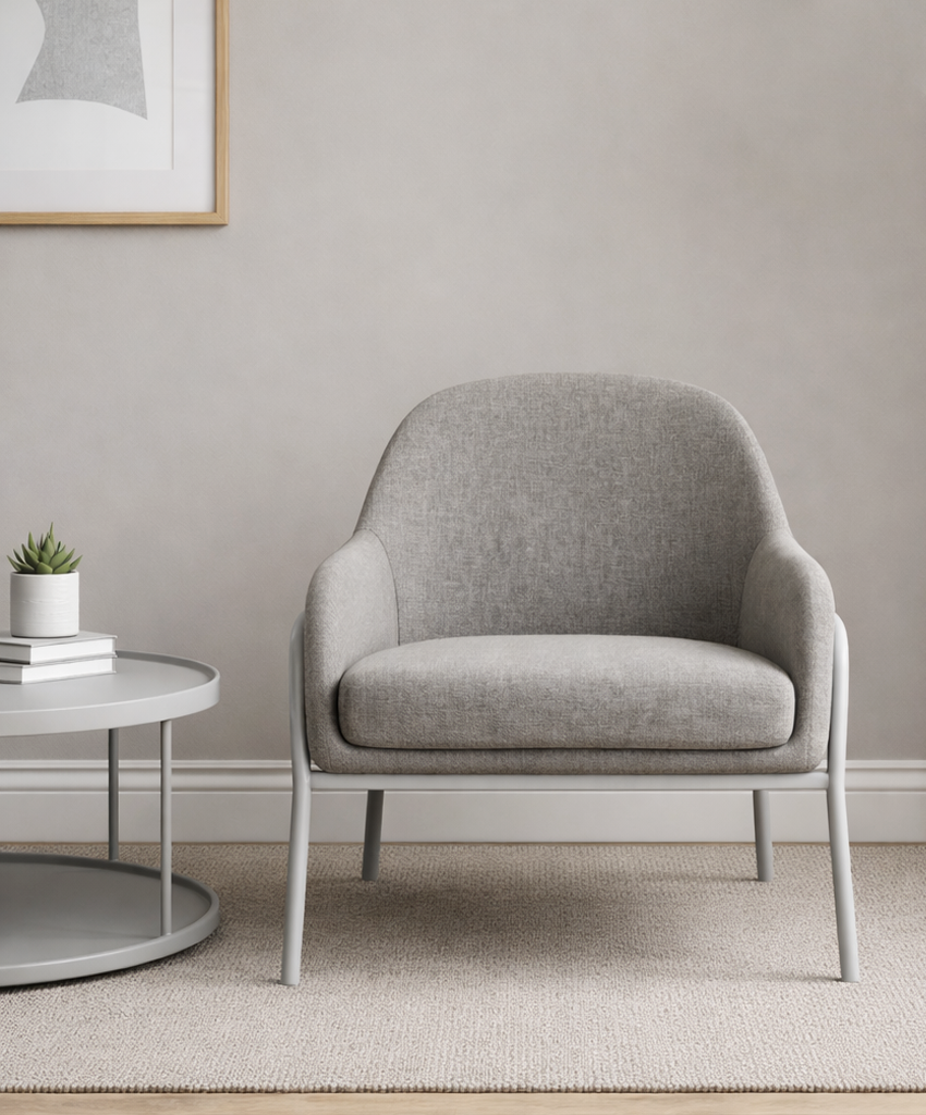 Grey armchair in a modern living room with a coffee table and lamp.