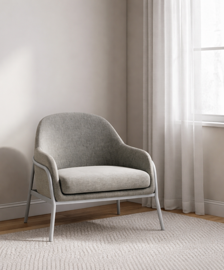 Grey armchair in a living room with neutral walls and curtains