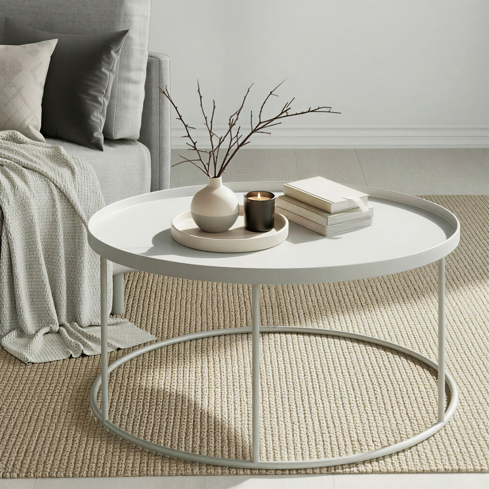 Round grey coffee table with decorative items in a living room setting