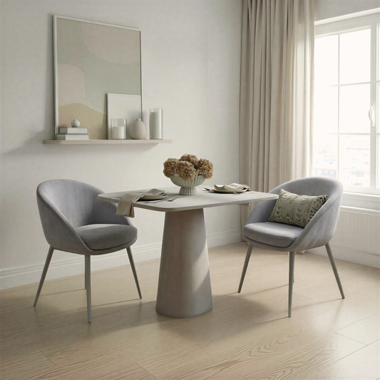 Modern dining room with a round table and two grey chairs.