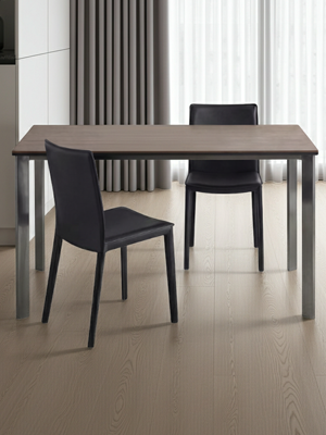 Modern dining table with two black chairs in a minimalistic room.