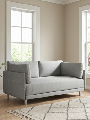 Grey sofa in a room with beige walls and large windows.